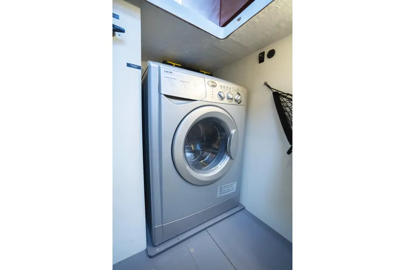 La Sirena Yacht Photos Pics Washing machine inside 2014 Jeanneau NC 14 boat, compact laundry area.