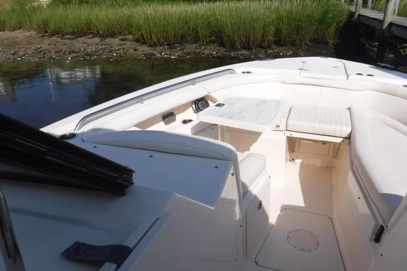  Yacht Photos Pics 2016 Grady White 355 Freedom boat interior with seating and table, near grassy shoreline.