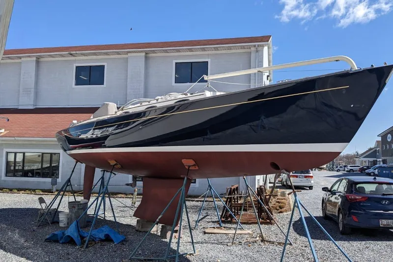  Yacht Photos Pics 2006 Alerion Express 38 sailboat on stands, outside a building, under a clear sky.