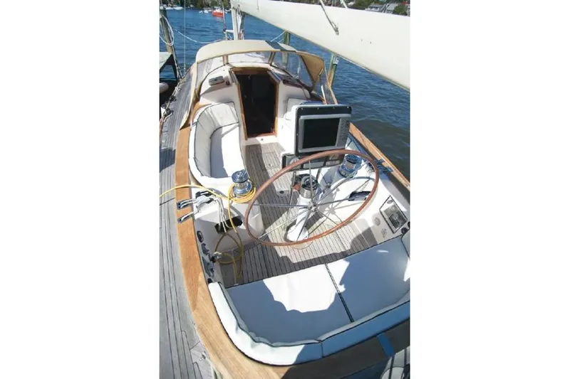  Yacht Photos Pics 2006 Alerion Express 38 sailboat cockpit with wooden wheel and seating on water.