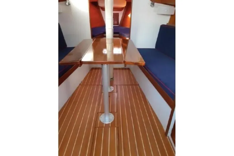  Yacht Photos Pics Interior of 2006 Alerion Express 38 sailboat with wooden table and blue seating.