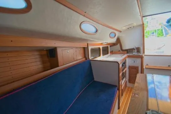  Yacht Photos Pics Interior of 2006 Alerion Express 38 sailboat with blue seating and wooden accents.