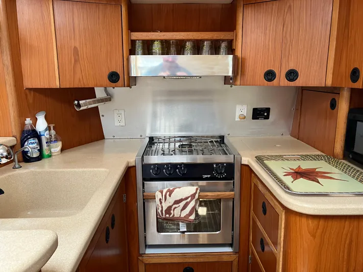 Bel Tempo Yacht Photos Pics 2008 Manta 42 MkIV yacht kitchen with stove, wooden cabinets, and countertop.