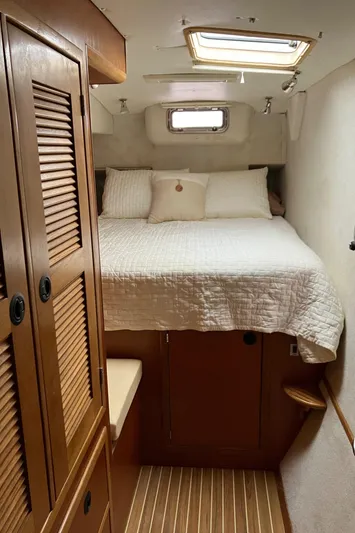 Bel Tempo Yacht Photos Pics Cozy cabin interior of 2008 Manta 42 MkIV with bed and wooden accents.