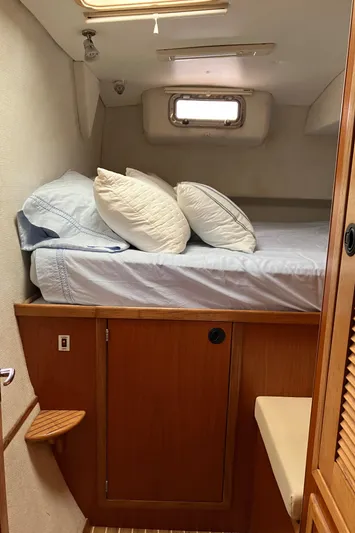 Bel Tempo Yacht Photos Pics Cozy cabin interior of 2008 Manta 42 MkIV with bed and wooden cabinetry.