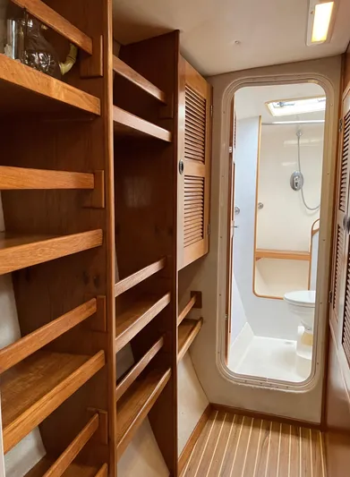 Bel Tempo Yacht Photos Pics Interior of 2008 Manta 42 MkIV yacht with wooden shelves and bathroom view.