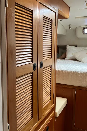 Bel Tempo Yacht Photos Pics Interior of 2008 Manta 42 MkIV yacht with wooden cabinets and cozy bed.