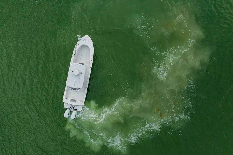  Yacht Photos Pics Aerial view of 2024 Orion 29CC boat navigating through green water.