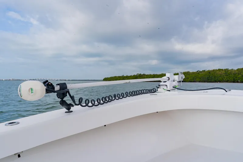  Yacht Photos Pics 2024 Orion 29CC boat with trolling motor on calm water, cloudy sky.
