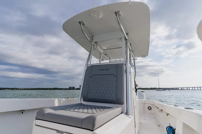  Yacht Photos Pics 2024 Orion 29CC boat with sleek seating, cruising on open water under cloudy skies.