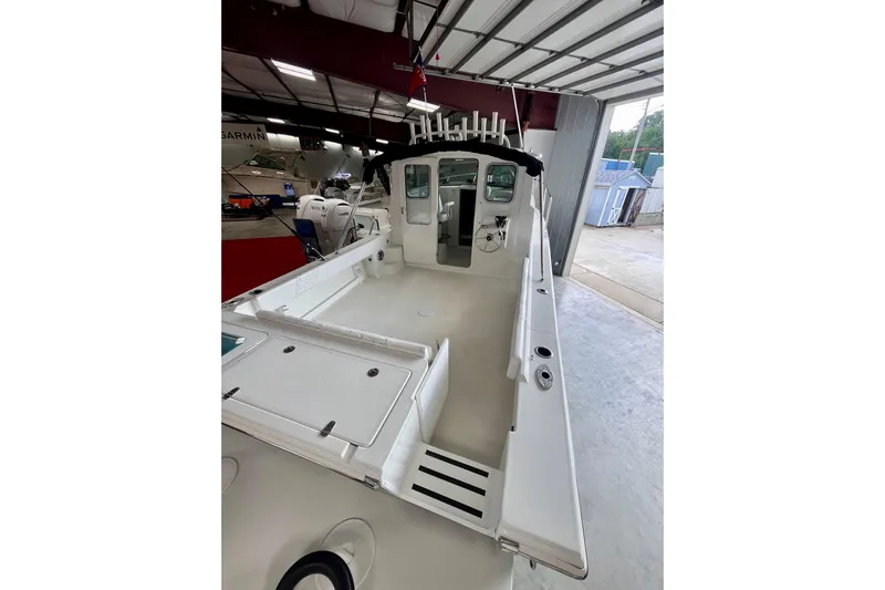  Yacht Photos Pics 2026 Parker 2520 XLD Sport Cabin boat in a showroom, showcasing spacious deck and cabin.