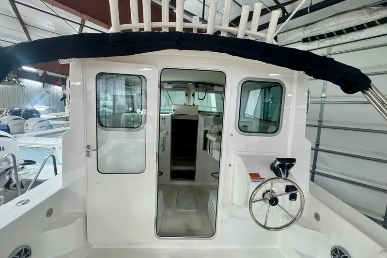  Yacht Photos Pics 2026 Parker 2520 XLD Sport Cabin boat interior with steering wheel and cabin entrance.