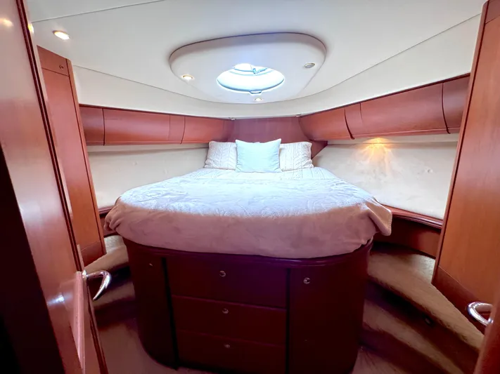 A Whole New World Yacht Photos Pics Luxurious cabin interior of 2006 Silverton 50 Convertible yacht with cozy bed and wooden finish.