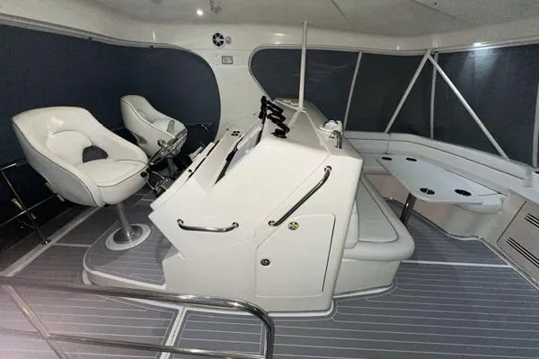 A Whole New World Yacht Photos Pics 2006 Silverton 50 Convertible yacht helm station with white captain chairs and modern controls.