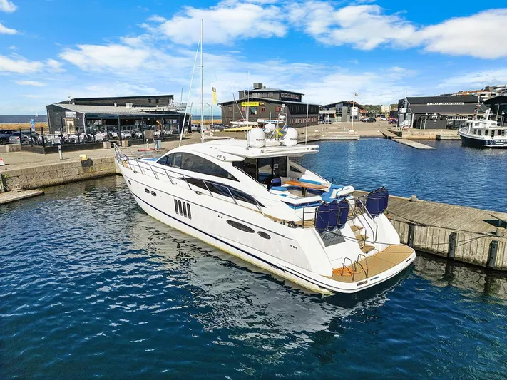  Yacht Photos Pics Luxury 2008 Princess V65 yacht docked in a marina under a clear blue sky.
