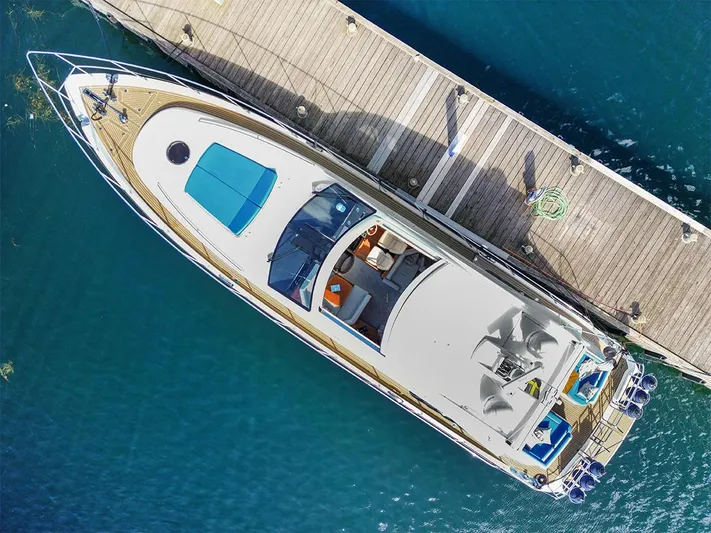  Yacht Photos Pics Aerial view of 2008 Princess V65 yacht docked at a wooden pier.