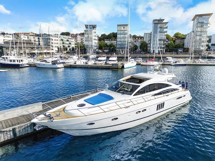  Yacht Photos Pics Luxury 2008 Princess V65 yacht docked in a marina with modern buildings in the background.