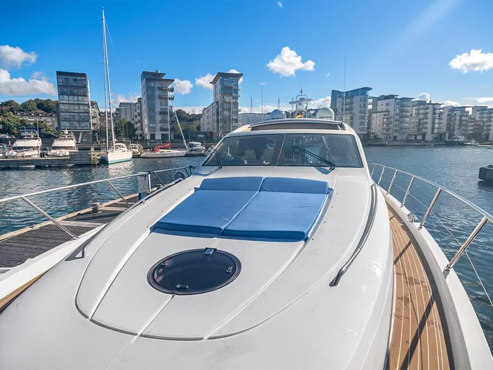  Yacht Photos Pics 2008 Princess V65 yacht docked in a marina with modern buildings in the background.