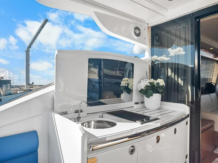  Yacht Photos Pics Luxurious 2008 Princess V65 yacht deck with sink, flowers, and seating under blue sky.