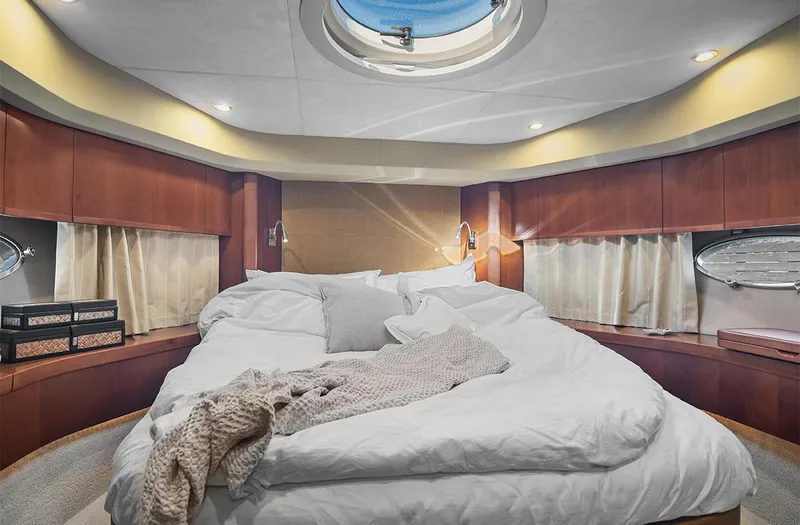  Yacht Photos Pics Luxurious bedroom interior of 2008 Princess V65 yacht with cozy bedding and elegant wood finishes.