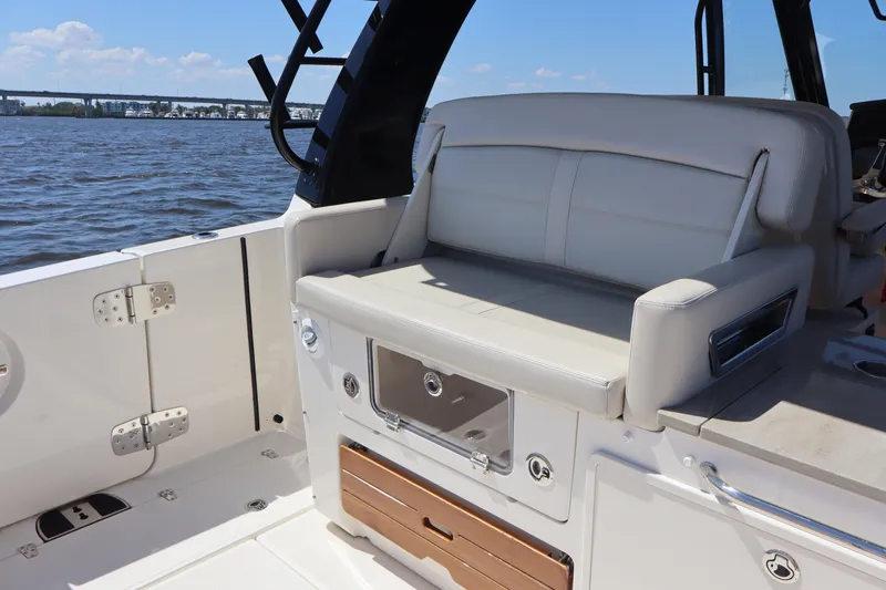  Yacht Photos Pics 2023 Boston Whaler 350 Realm boat interior with white seating and storage compartments.