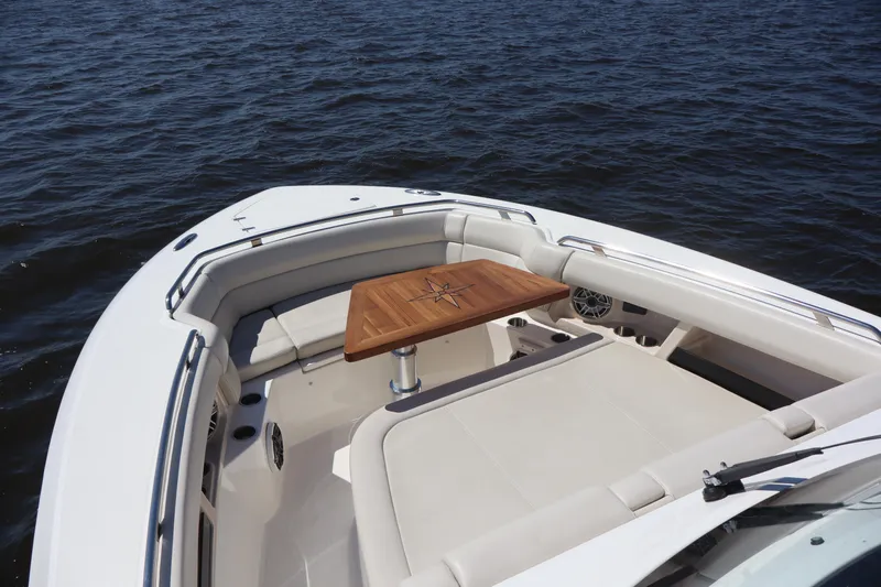  Yacht Photos Pics 2023 Boston Whaler 350 Realm boat interior with wooden table on calm water.