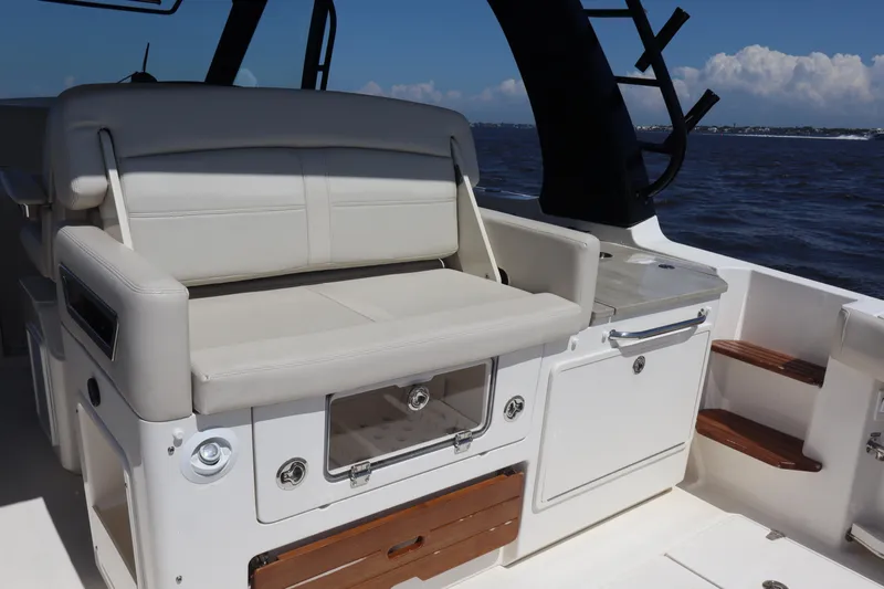  Yacht Photos Pics 2023 Boston Whaler 350 Realm interior with seating and storage, ocean view in background.