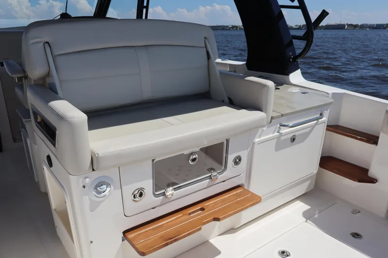  Yacht Photos Pics 2023 Boston Whaler 350 Realm interior with cushioned seating and storage, overlooking the water.