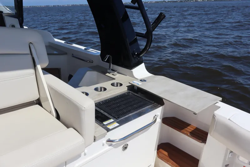  Yacht Photos Pics 2023 Boston Whaler 350 Realm boat interior with seating and grill, on open water.