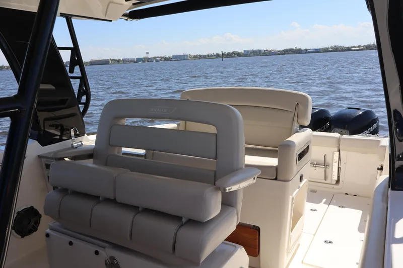  Yacht Photos Pics 2023 Boston Whaler 350 Realm boat interior with seating, overlooking calm waters.