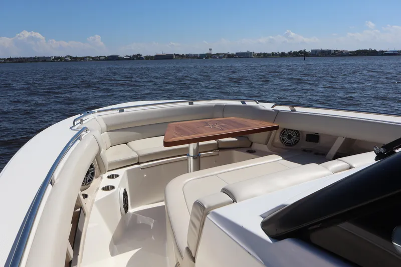  Yacht Photos Pics 2023 Boston Whaler 350 Realm boat interior with seating and table on open water.
