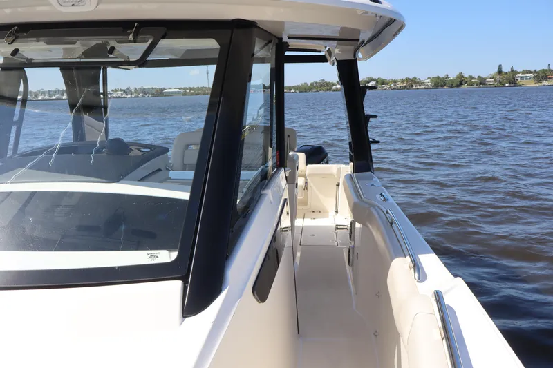  Yacht Photos Pics 2023 Boston Whaler 350 Realm boat on calm water, showcasing sleek design and spacious deck.