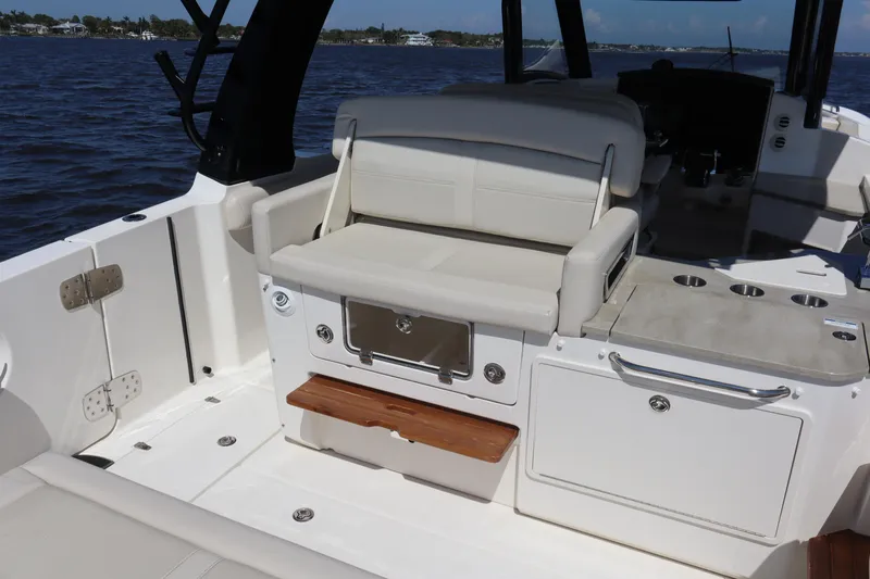  Yacht Photos Pics 2023 Boston Whaler 350 Realm interior with seating and storage, on a calm water backdrop.