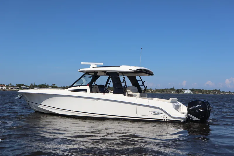  Yacht Photos Pics 2023 Boston Whaler 350 Realm boat on water, side view, clear sky background.