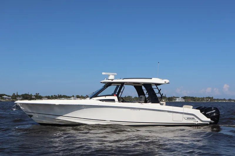  Yacht Photos Pics 2023 Boston Whaler 350 Realm boat cruising on open water under clear blue sky.