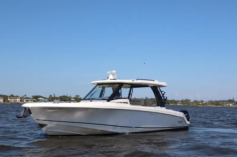  Yacht Photos Pics 2023 Boston Whaler 350 Realm boat on calm water under clear blue sky.