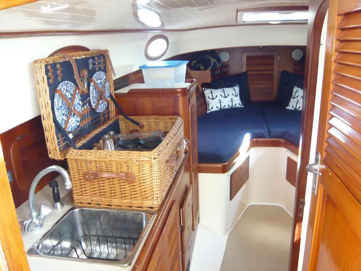 Courage Yacht Photos Pics Cozy interior of 1998 Hinckley 36 Classic yacht with wicker basket and nautical decor.