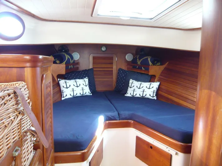 Courage Yacht Photos Pics Cozy cabin interior of 1998 Hinckley 36 Classic with nautical-themed pillows and wooden finish.