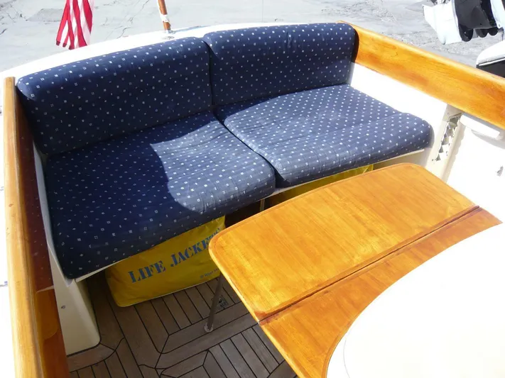 Courage Yacht Photos Pics Hinckley 36 Classic 1998 boat interior with blue cushioned seating and wooden table.
