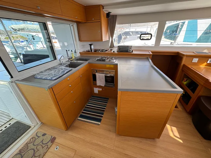  Yacht Photos Pics Modern kitchen interior of 2017 Lagoon 450 F catamaran with wooden cabinetry and ample counter space.