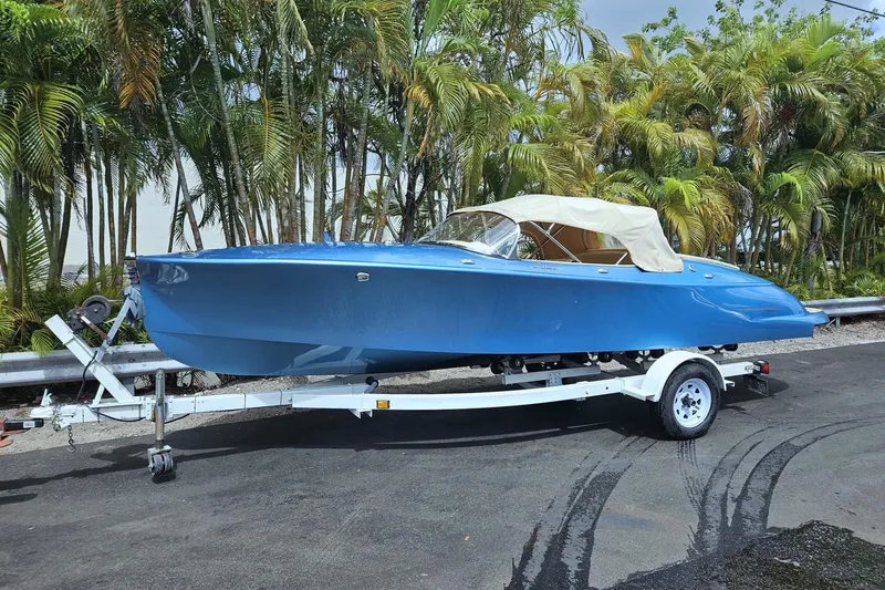  Yacht Photos Pics 2022 Seven Seas Yachts Hermes Speedster in blue on a trailer, surrounded by palm trees.