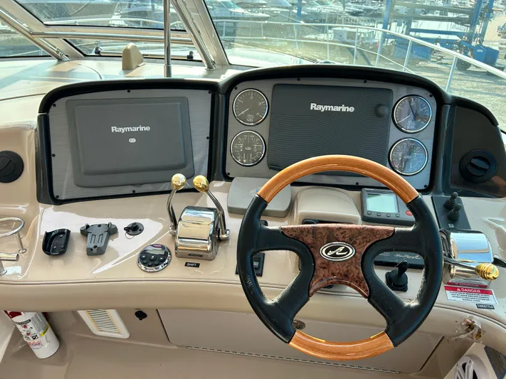  Yacht Photos Pics 2007 Sea Ray 52 Sundancer helm with Raymarine displays and wood-accented steering wheel.