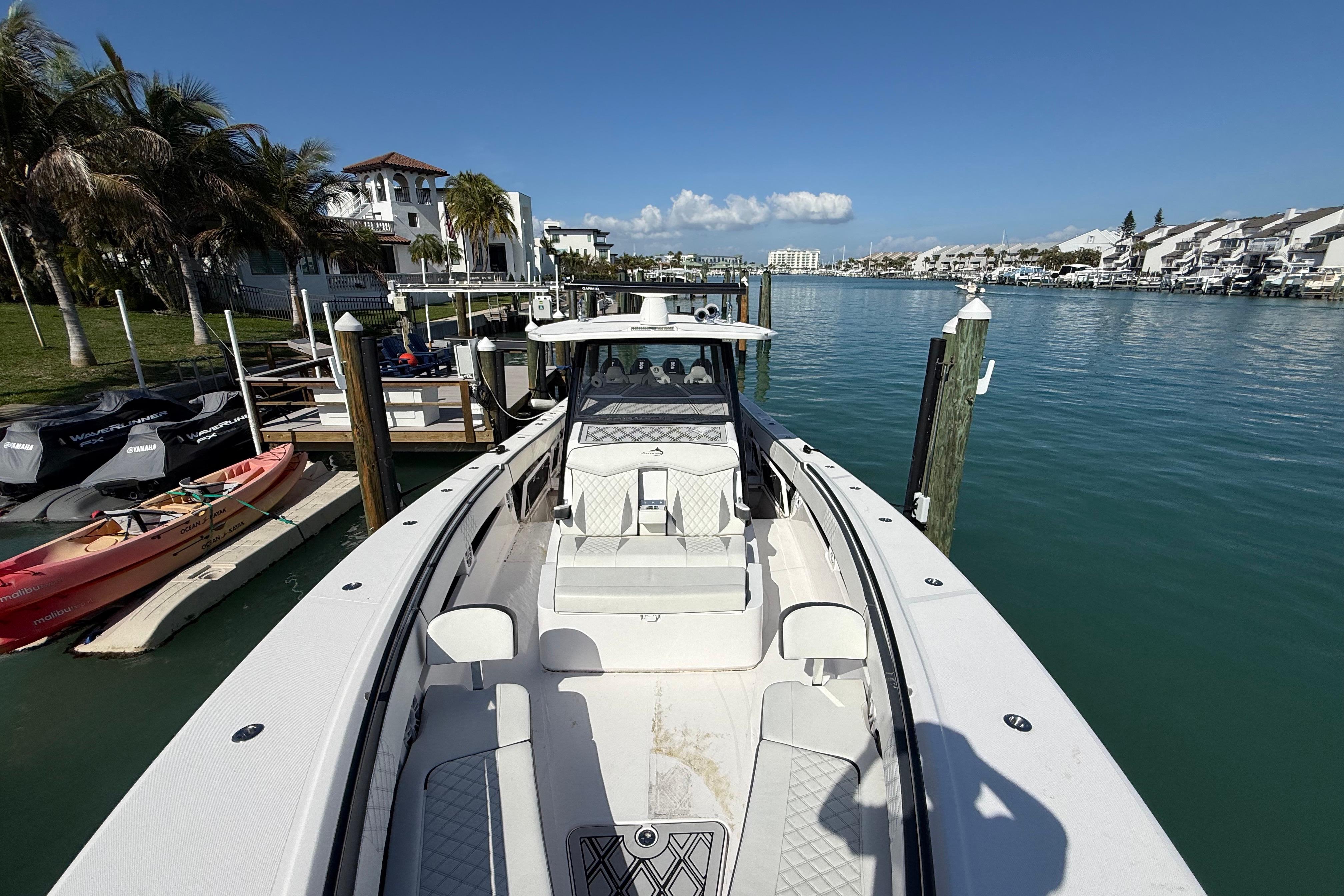Streamline 45 boat docked in a scenic marina, surrounded by palm trees and waterfront homes.