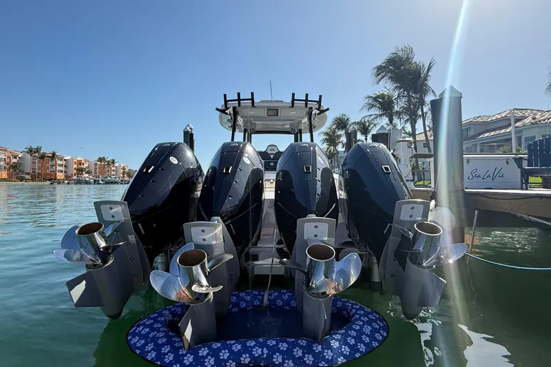  Yacht Photos Pics Four powerful outboard motors on a 2020 Streamline 45 boat docked by palm trees.