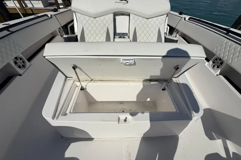  Yacht Photos Pics Open storage compartment on a 2020 Streamline 45 boat, featuring quilted seating and marine speakers.