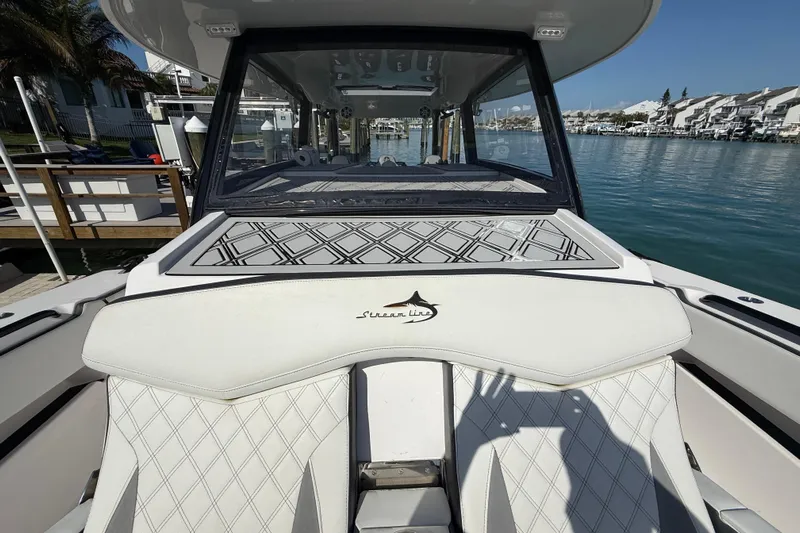  Yacht Photos Pics 2020 Streamline 45 boat with white seating, docked by waterfront homes.