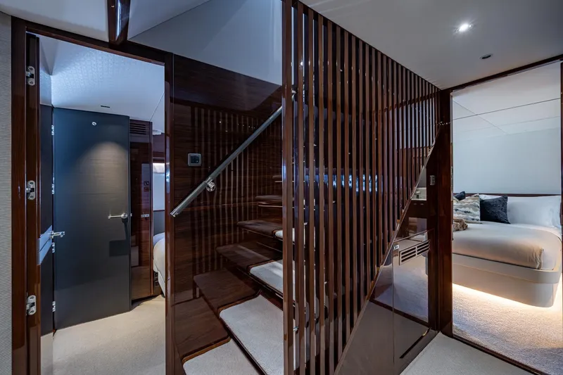  Yacht Photos Pics Luxurious interior of 2022 Princess X95 yacht with elegant staircase and cozy bedroom.