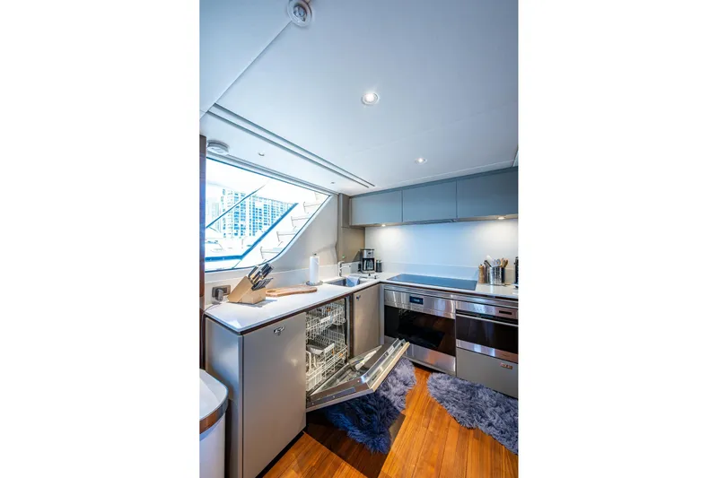  Yacht Photos Pics Modern kitchen interior on 2022 Princess X95 yacht, featuring sleek appliances and wooden flooring.