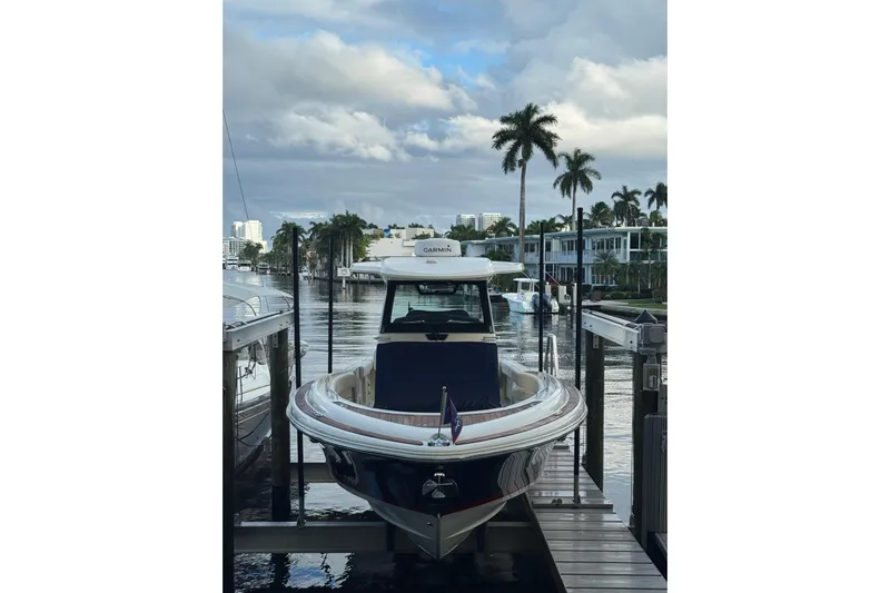 Para-dice Yacht Photos Pics 2023 Chris-Craft Catalina 30 docked by palm trees and waterfront homes.