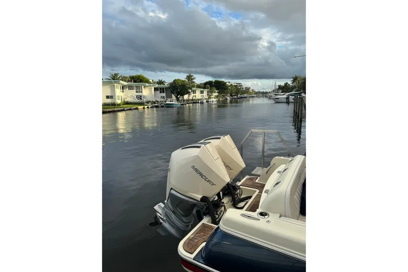 Para-dice Yacht Photos Pics 2023 Chris-Craft Catalina 30 boat on a serene canal with cloudy skies.